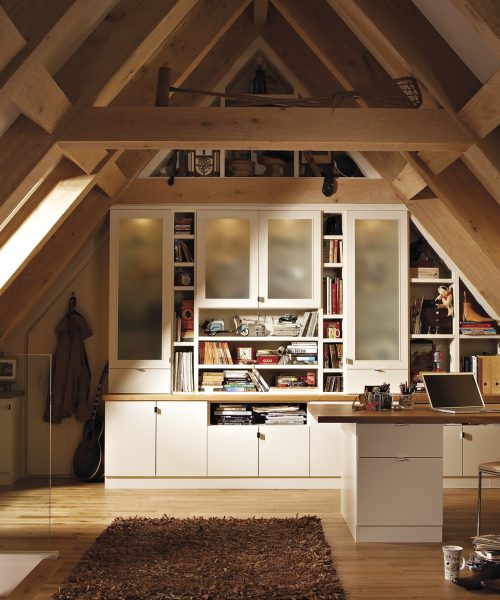 Stylish attic home office featuring wooden beams, desk, bookshelves, and cozy decor for a productive workspace.